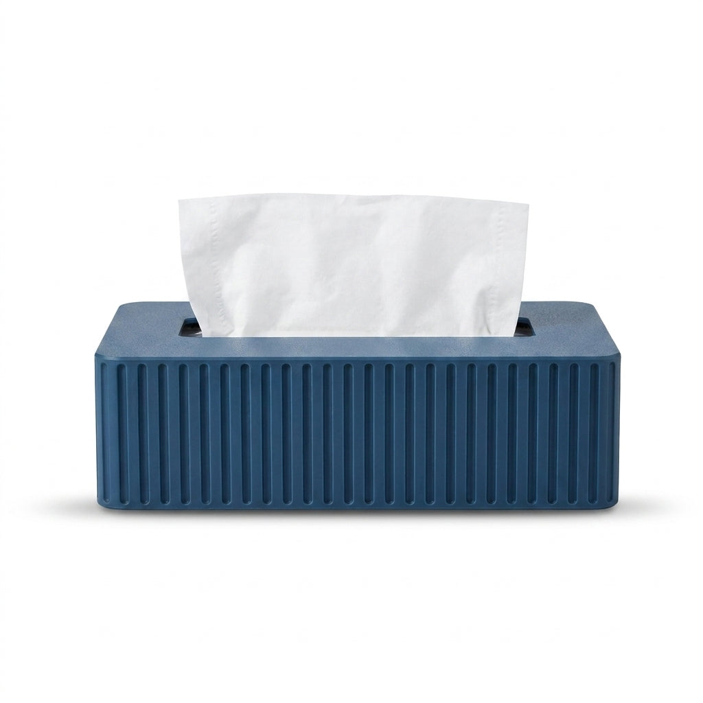 A rectangular blue tissue box cover with vertical ribbed detailing on the front, holding a white tissue paper, shown against a plain white background.