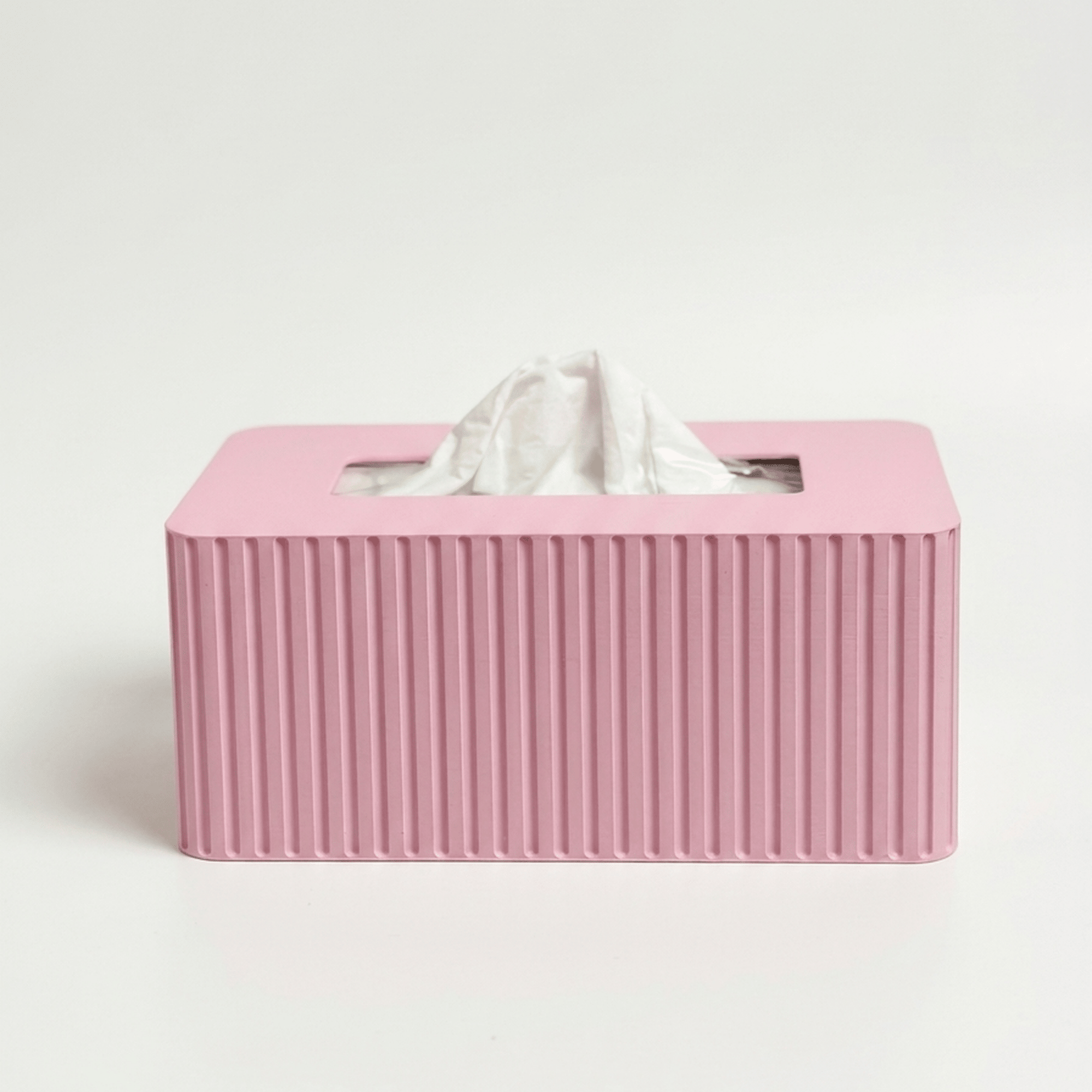 Pink tissue box with fluted texture on a white background