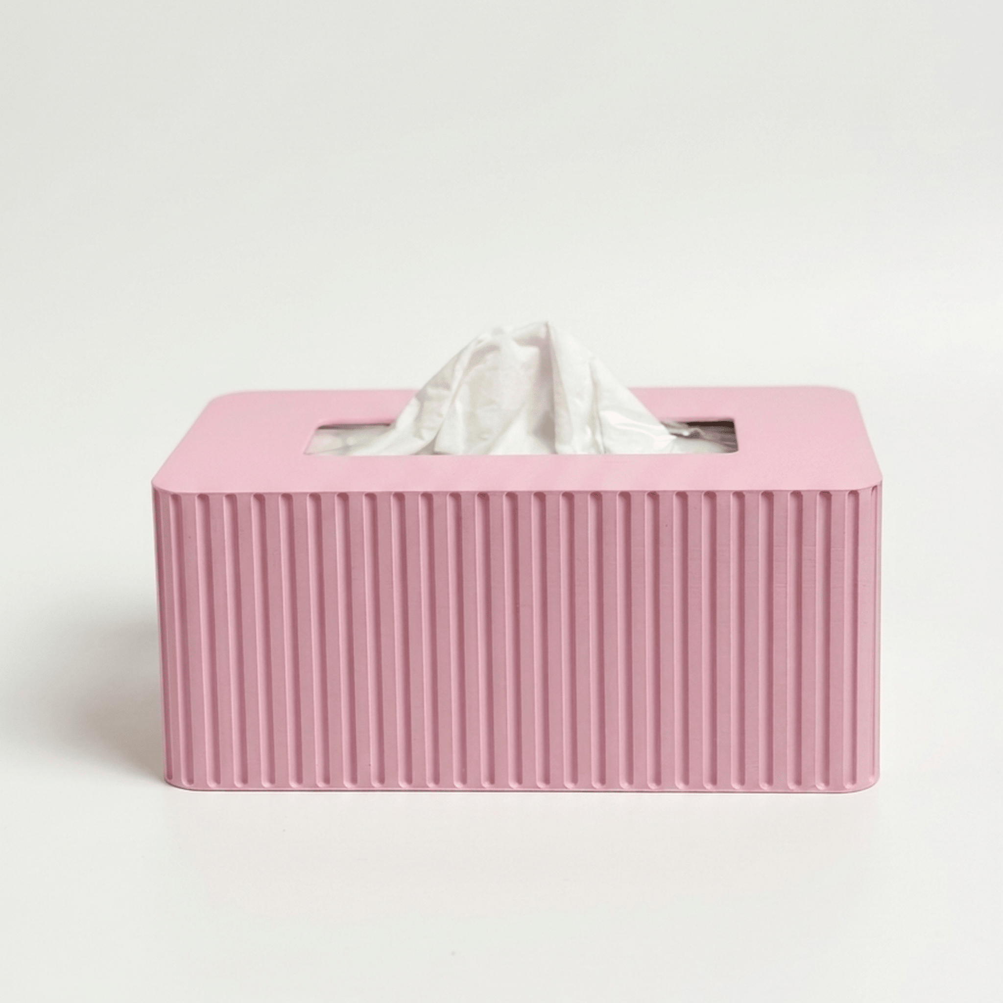 Pink tissue box with fluted texture on a white background