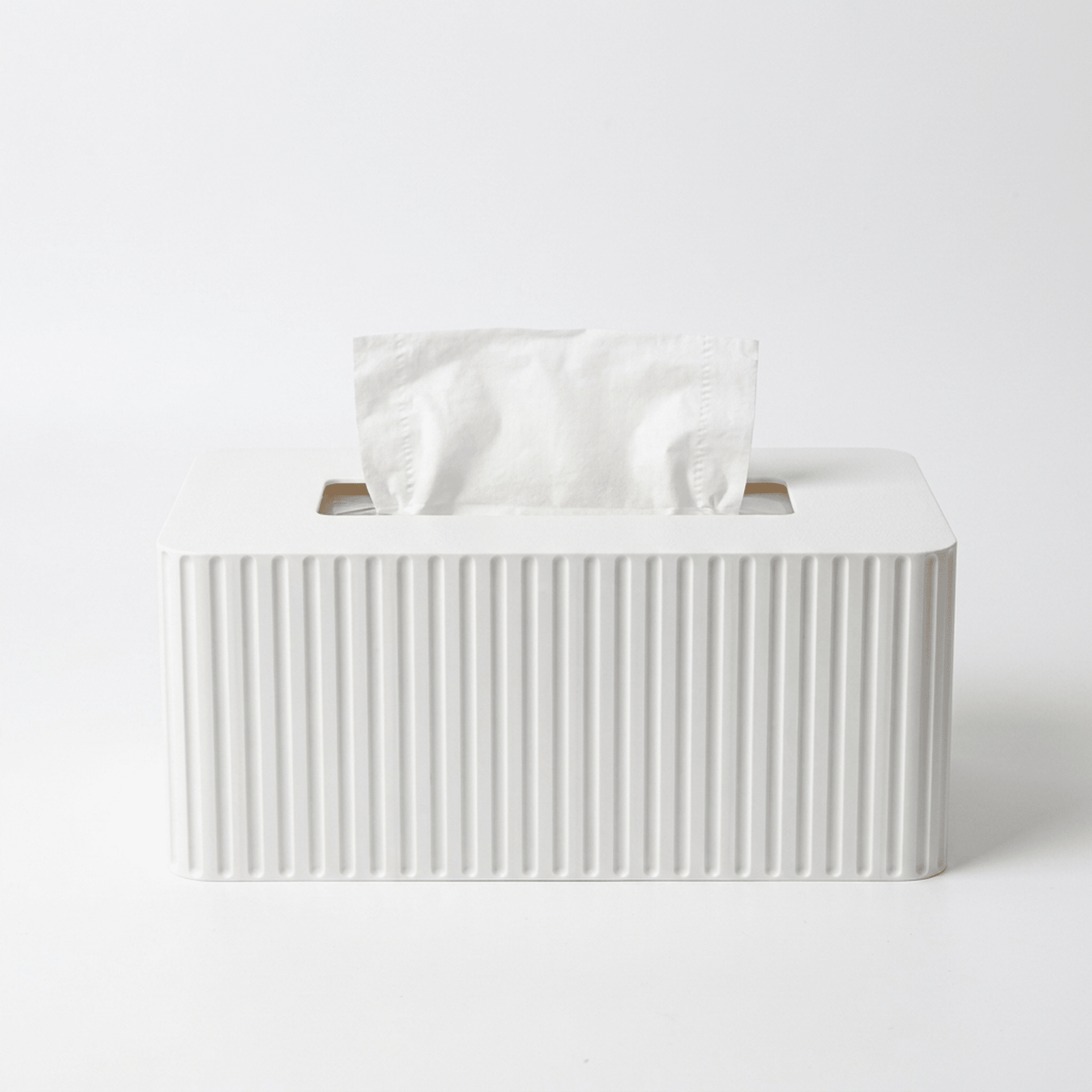 White tissue box with fluted design on a light gray background